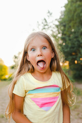 Little girl showing tongue at camera outdoor
