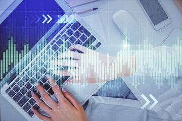 Double exposure of woman hands working on computer and forex chart hologram drawing. Top View....