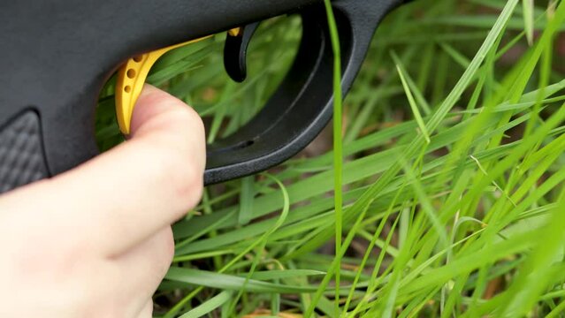Removing the gun safety before pulling the trigger, black hunting rifle without ammunition.