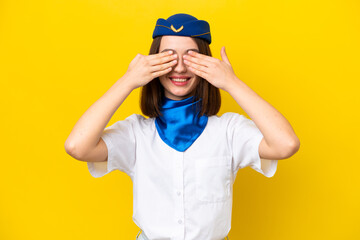 Airplane stewardess Ukrainian woman isolated on yellow background covering eyes by hands