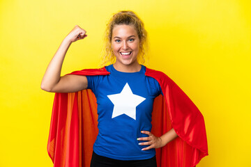 Girl with curly hair isolated on yellow background in superhero costume and doing strong gesture