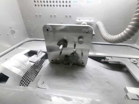 Platform with Objects Printed From Metal Powder Stands in Working Chamber Inside 3D Printer for Metal. Laser Sintering Machine for Metal Inside. Platform with Printed Objects Covered Metal Powder.