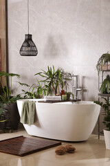 Modern white tub and beautiful green houseplants in bathroom. Interior design - obrazy, fototapety, plakaty