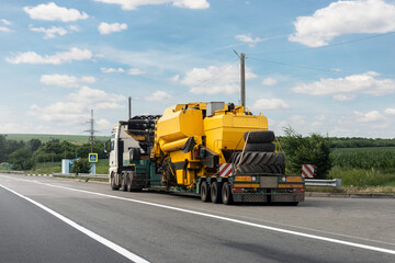 Long heavy industrial truck with semi trailer platform transport disassembled combine harvester...