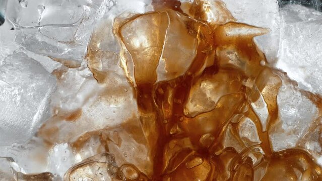 Super Slow Motion Shot of Pouring Coffee into Glass with Ice Cubes