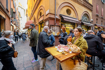 Woman eating italian meat appetizer, various sliced meat and cheese with bread and Aperol Spritz at bar or restaurant outdoors. Concept of Italian lifestyle and gastronomy - obrazy, fototapety, plakaty