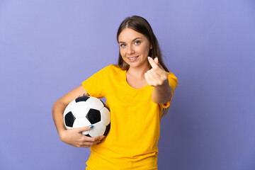 Young Lithuanian football player woman isolated on purple background making money gesture