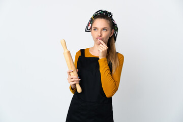 Young Lithuanian woman holding a rolling pin isolated on white background having doubts while looking up