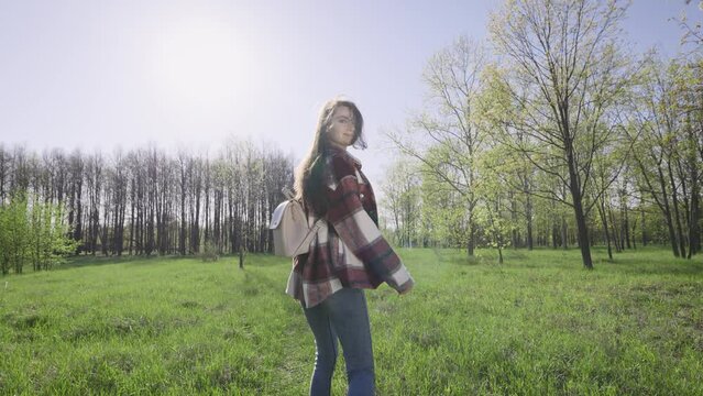 Beautiful young woman walks in nature. Carefree and happy weekend.