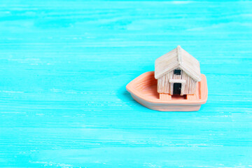 Toy boat transports a tiny wooden house