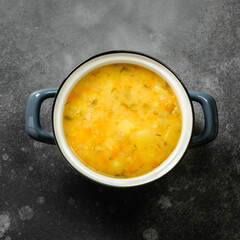 Healthy split pea soup puree in pot on dark background. Top view, flat lay, copy space.