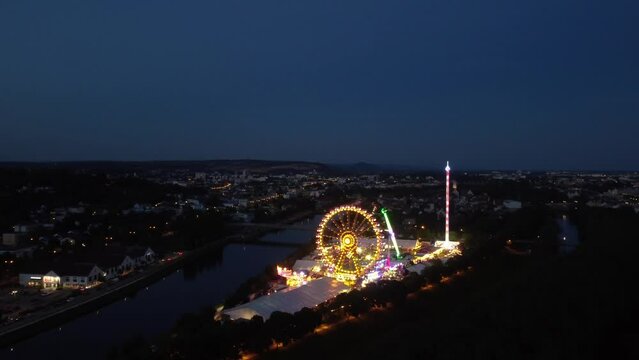 Drone panning move of the fair Maidult in Regensburg, Bavaria, Germany with ferris wheel and beer tents at night