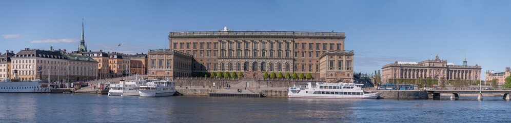 The Swedish Royal Castle in the old town island Gamla Stan and commuting boats a sunny day in Stockholm