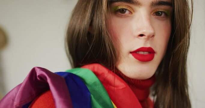 Portrait of caucasian non-binary transgender woman holding lgbt flag