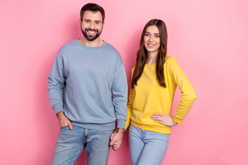 Portrait of two cheerful lovely people hold arms toothy smile isolated on pink color background