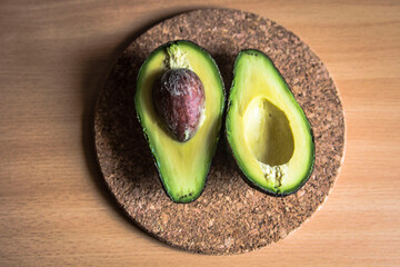 Avocado cut in half on a wooden board
