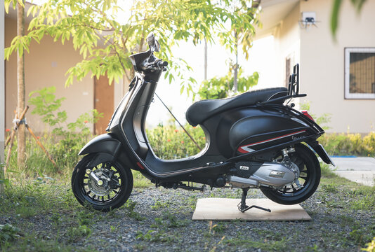 Vespa Sprint classic scooter 150 cc black matt color at side view. Vintage motorcycle or motorbike with crash bar has been washed, cleaned at outdoor evening on April 3, 2022 in Chiang Mai, Thailand.
