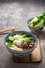 Traditional asian noodle soup with bok choi and chicken in ceramic bowl. - 505879892