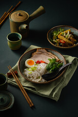 Asian noodle soup on table, ramen with pork, vegetables and egg in a bowl. Copy space - 505880025