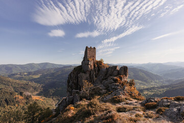 Fototapeta na wymiar Medieval castle of Rochebonne in ruins under a beautiful cloudy sky, France