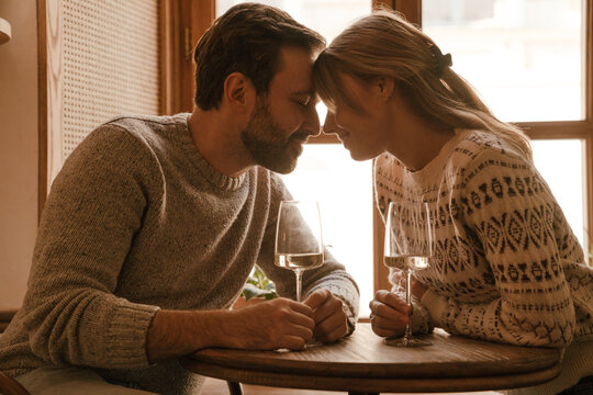 White romantic couple drinking wine during date in cafe