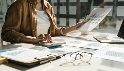 Close up a woman working about financial with calculator at her office to calculate expenses, Accounting concept
