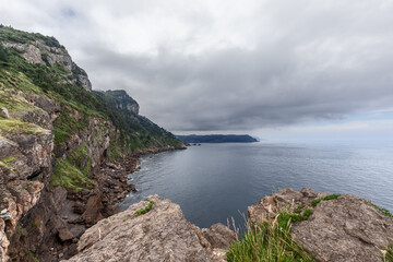 Very distant perspective, including ridge of Cabo de Santa Catalina cliffs, narrow coastal strip, still waters of Bay of Biscay. Lequeitio, Basque Country, Spain