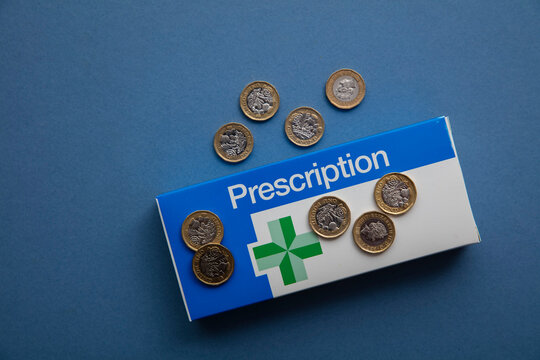 OXFORD, UK - May 2022: NHS medical prescription packaging with money. Healthcare cost concept