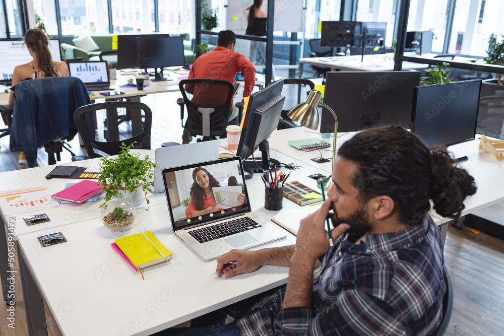 Canvas Prints Businesswoman briefing reports to african american male colleague through laptop in office