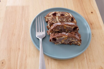 Homemade mosaic chocolate biscuit cake served in a blue plate, selective focus. It is called "Mozaik Pasta" in Turkish. That is texture of it not grain. Traditional Turkish dessert.