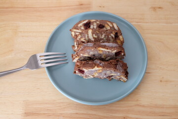 Homemade mosaic chocolate biscuit cake served in a blue plate, selective focus. It is called 