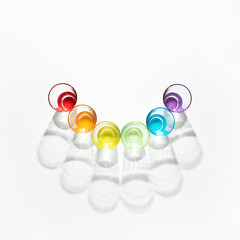Minimal creative concept made with sunlit colorful glasses on white background. Vibrant rainbow aesthetic.
