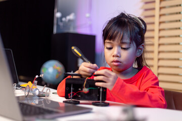 Asia students learn at home in coding robot cars and electronic board cables in STEM, STEAM, mathematics engineering science technology computer code in robotics for kids concept.