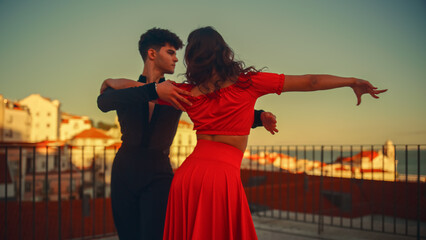 Beautiful Couple Dancing a Latin Dance Outside the City with Old Town in the Background. Sensual Dance by Two Professional Dancers on a Sunset in Ancient Culturally Rich Tourist Location. - obrazy, fototapety, plakaty