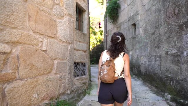 girl walking in the traditional streets of Combarro, a typical coastal village in Rias Baixas in the coast of Galicia, Spain