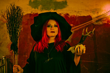 Witch in a red-haired hat. Halloween concept.