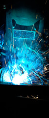 Welder uses torch to make sparks during manufacture of metal equipment