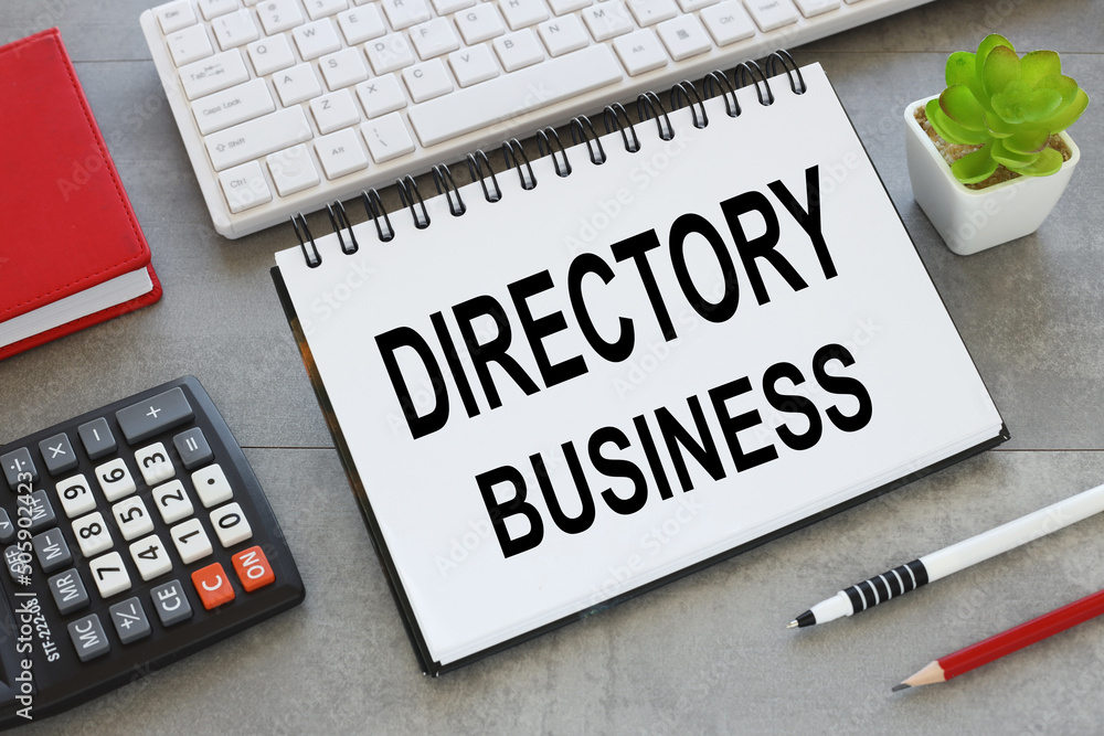 Aufkleber directory business text on an open notepad on a gray background. calculator. notebook.