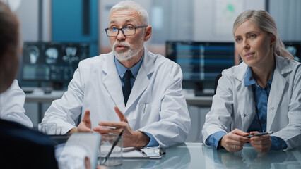Hospital Conference Meeting Room: Senior Neuroscientist Uses Tablet Computer with MRI Magnetic...