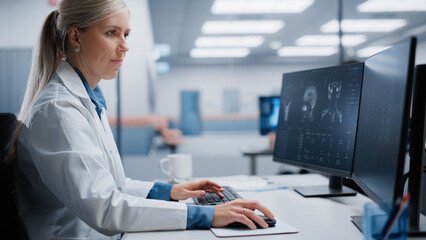 Medical Hospital Research Lab: Female Neurosurgeon Using Computer with Brain Scan MRI Images,...