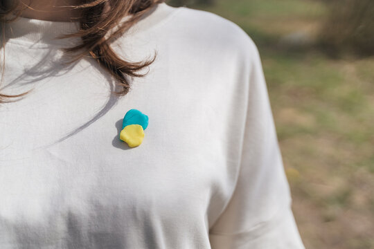 Crop anonymous woman with Ukrainian flag brooch on t shirt