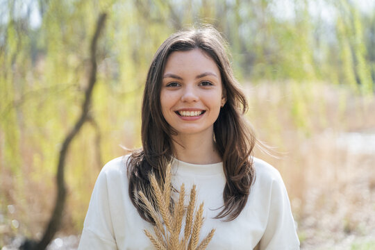 Female looking at camera with bunch of spikelets in nature