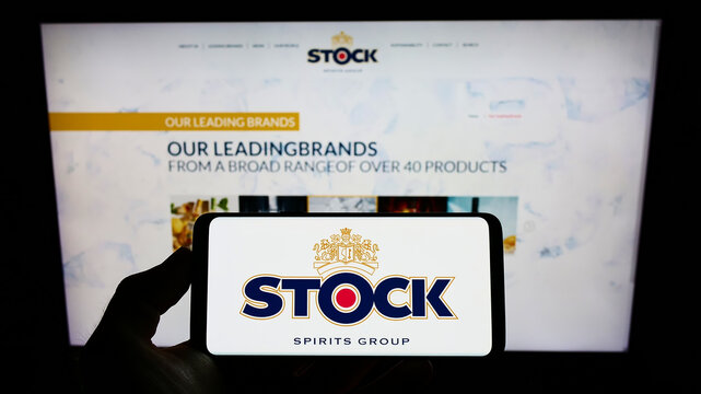 Stuttgart, Germany - 05-15-2022: Person holding mobile phone with logo of British company Stock Spirits Group plc on screen in front of business web page. Focus on phone display.