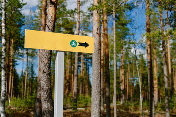 Yellow sign for hiking and biking trails on a sunny spring day