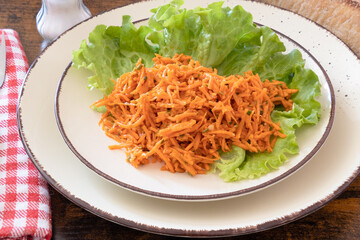 grated carrot on a plate with salad