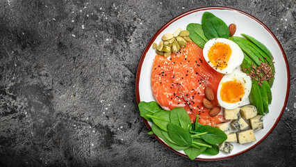 Fototapeta na wymiar Ketogenic diet breakfast. salmon, avocado, cheese, egg, spinach and nuts. Healthy fats, clean eating for weight loss. banner, menu, recipe place for text, top view