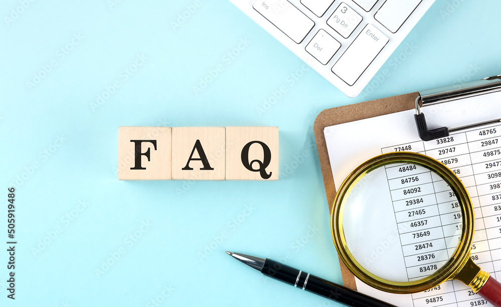 Poster faq word on wooden cubes on blue background with chart and keyboard