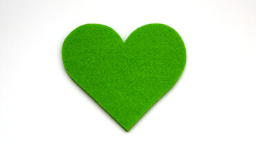 Green colored heart shape made of felt shot on white.