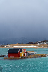 Traditional norwegian houses in small island in Sommarøy region with a blue sea and mountains - Tromso, Norway