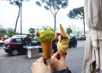 Close up focus of female hand holding melting delicious ice cream gelato in Italy